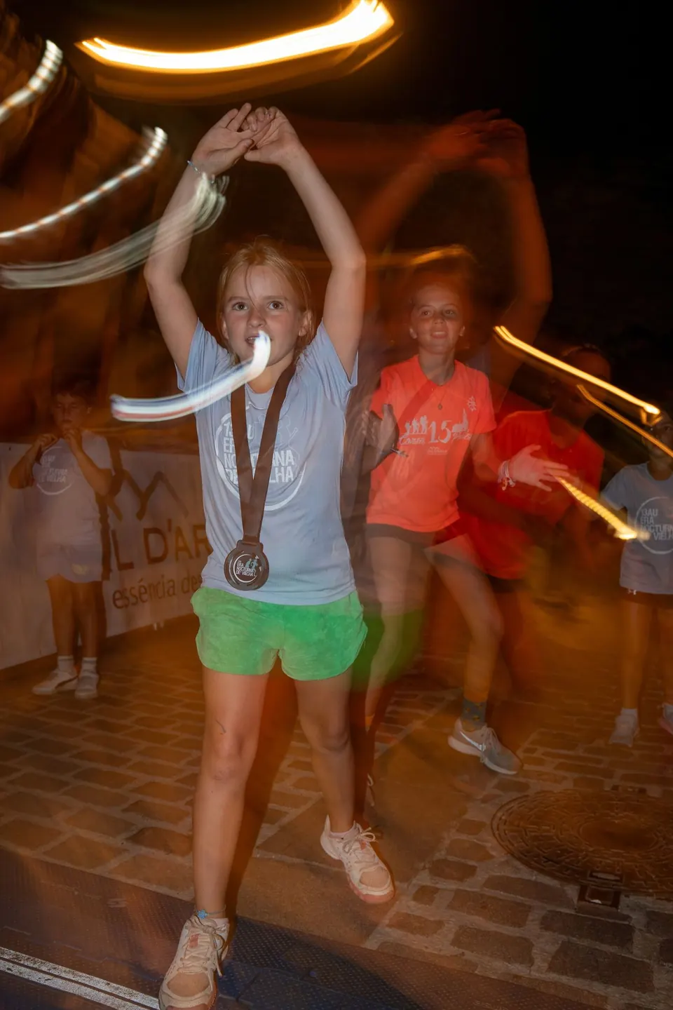 Una niña con su medalla baila entre luces