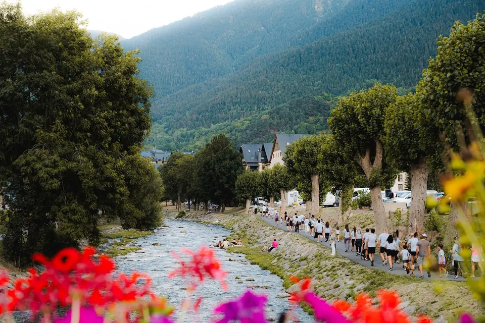 El río a su paso por Vielha, con caminantes al fondo